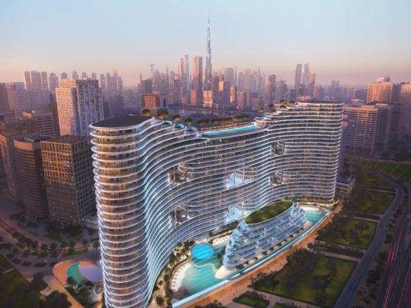 A futuristic, wavy glass building—Binghatti Aquarise—with illuminated edges stands amid greenery and pools, surrounded by city skyscrapers at sunset, with the Burj Khalifa visible in the distant skyline.