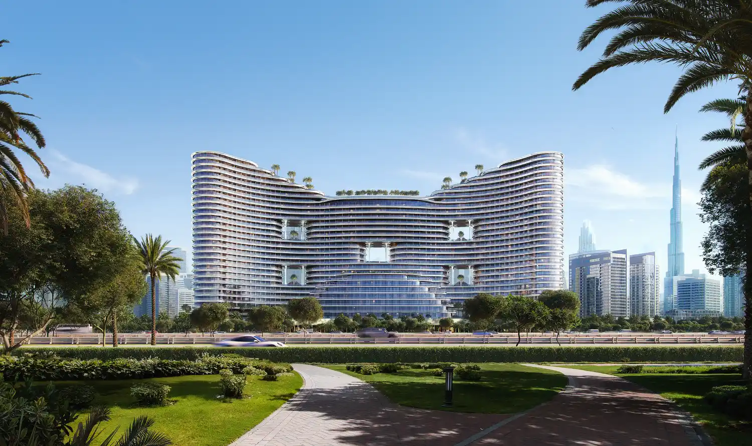 A modern, curved high-rise building with balconies and rooftop greenery, inspired by Binghatti Aquarise, stands amid a landscaped park with palm trees under a clear blue sky. A tall skyscraper rises in the distant background.