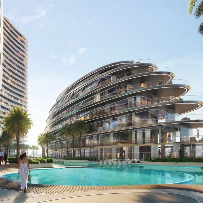 A futuristic, curved glass building—Binghatti Aquarise—with multiple balconies overlooks a circular swimming pool, surrounded by palm trees. A person in white walks near the pool in this tropical, modern setting.
