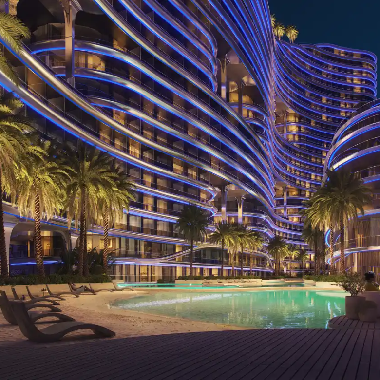 A luxurious, modern hotel, Binghatti Aquarise, features wavy blue neon lights that illuminate the night, overlooking a palm-lined pool area with lounge chairs, lush greenery, and a stunning city skyline in the background.
