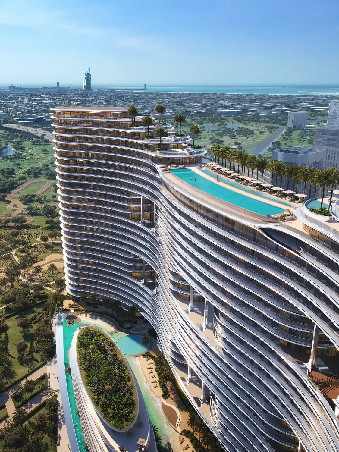 A modern, curved high-rise building—Binghatti Aquarise—with rooftop pools and palm trees overlooks a cityscape and coastline, with another iconic sail-shaped building visible in the distance.