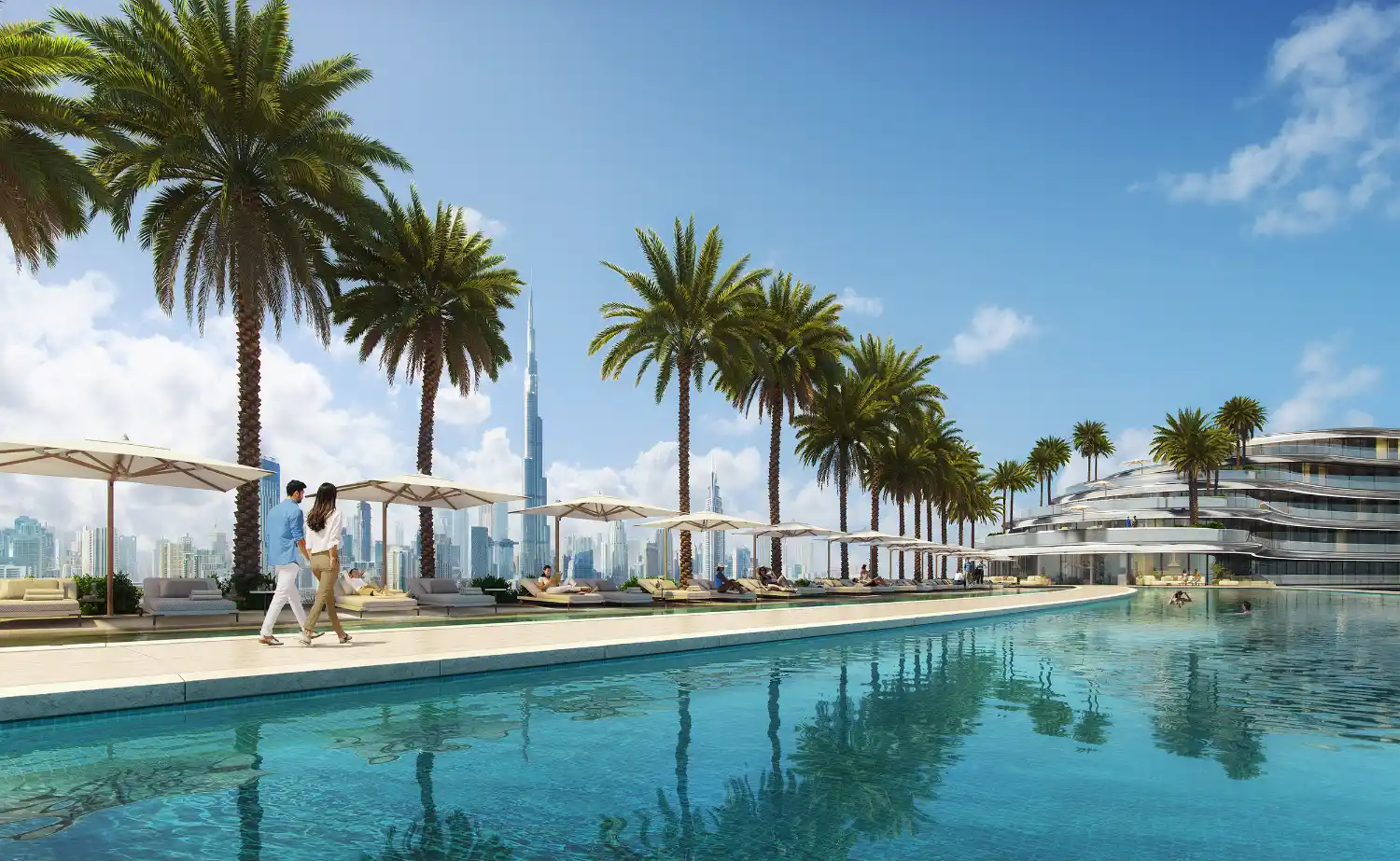 A couple walks beside the luxurious outdoor pool at Binghatti Aquarise, lined with palm trees and sun loungers, with a city skyline and the Burj Khalifa visible in the background under a bright blue sky.