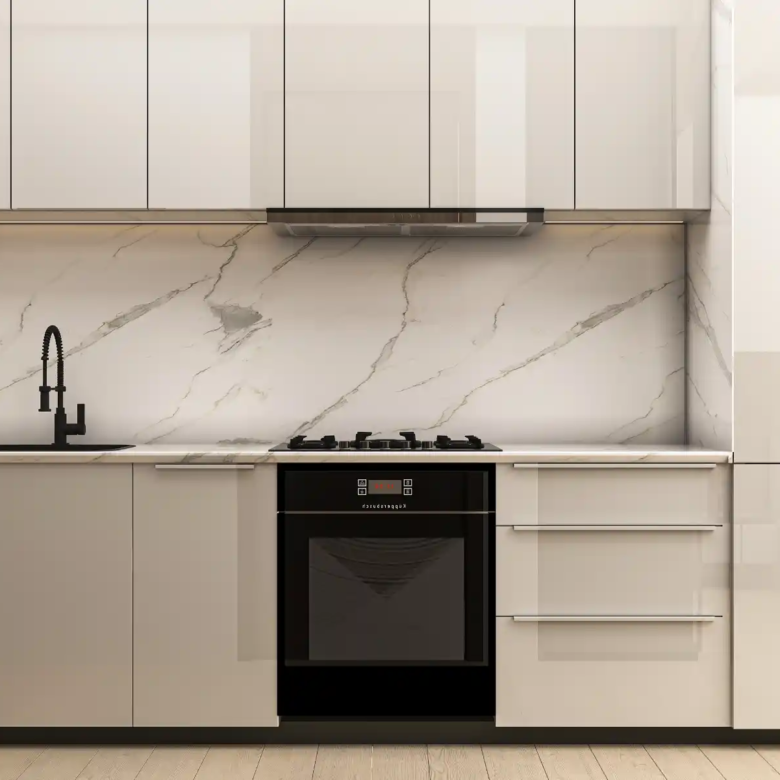 Modern kitchen in Binghatti Apex with glossy beige cabinets, marble backsplash, black oven and stove, black faucet, and light wood flooring. The overall design is sleek and minimalist.